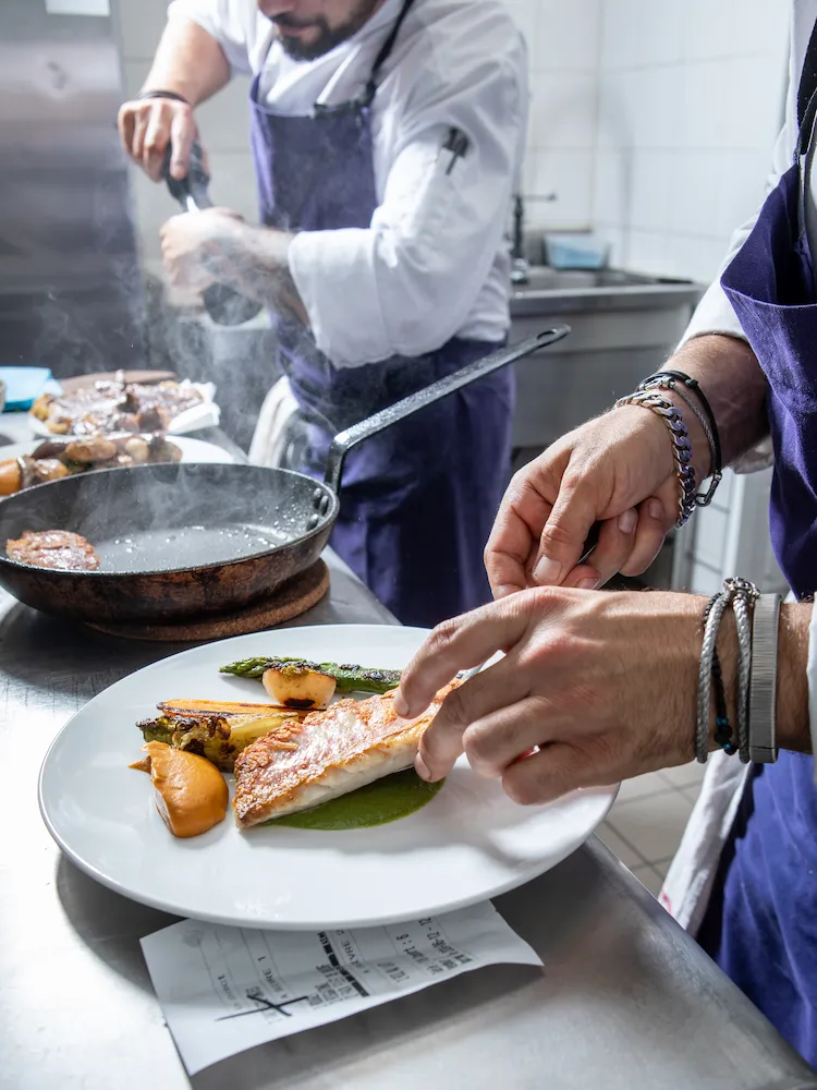Reportage photo restaurant – geste de dressage de plat en cuisine